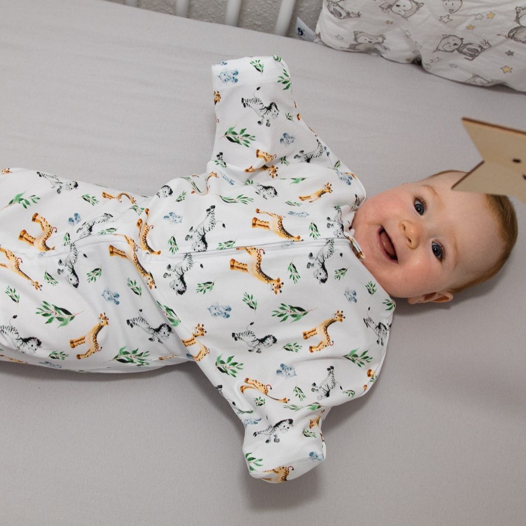 Baby liegt lächelnd im Bett