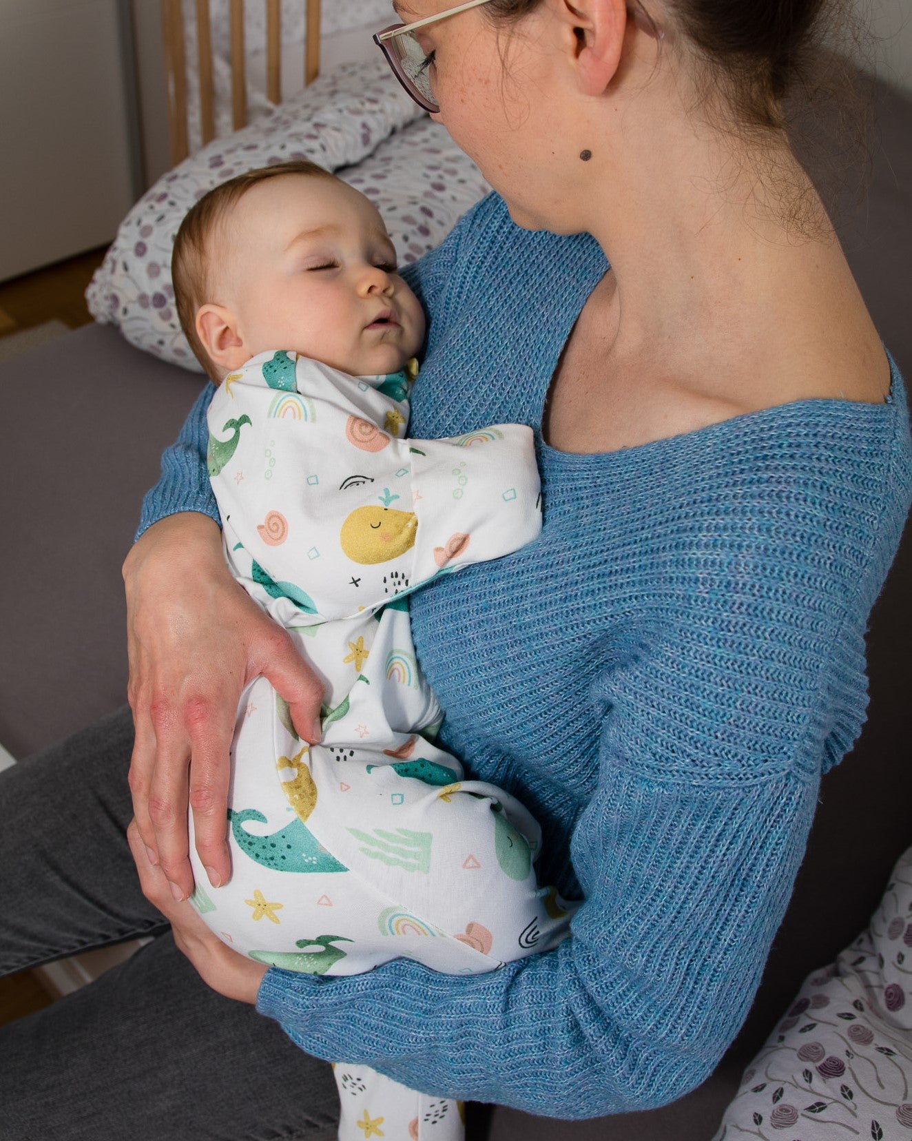 Baby wird in den Armen der Mutter gehalten und schläft